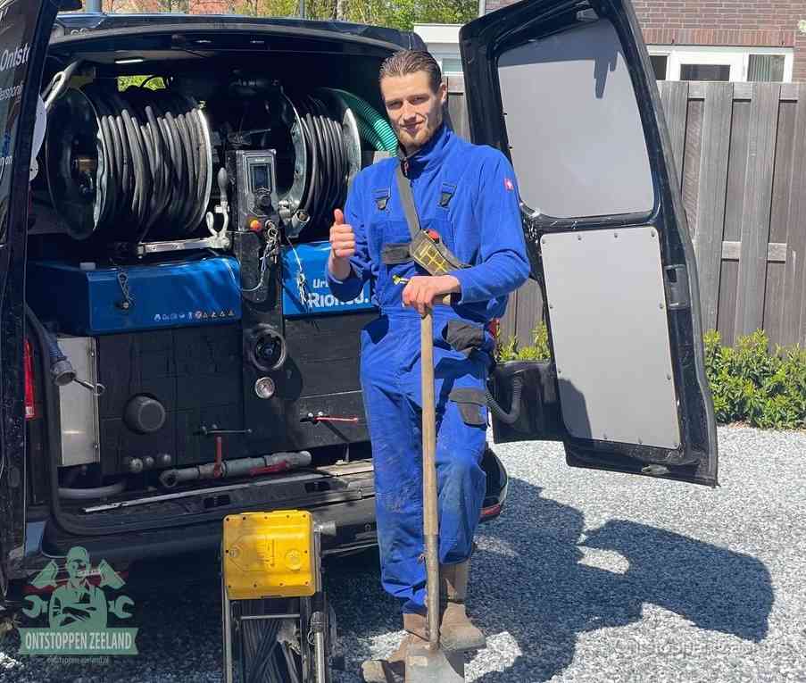 Een tevreden monteur met opgestoken duim naast de bestelbus, slim ingrijpen bespaart kosten bij een verstopte afvoer in Zeeland