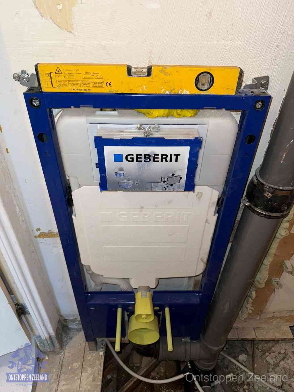 Een Geberit inbouwreservoir met frame voor een hangtoilet tegen de wand, met de afvoerbocht naar de vloer, kenmerkend voor een verstopt hangtoilet in Zeeland