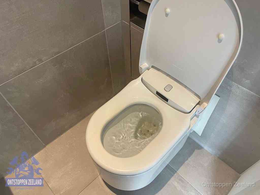 Een toiletpot vol troebel water met drijvend papier en restanten, de meest voorkomende oorzaak van een verstopte wc in Zeeland