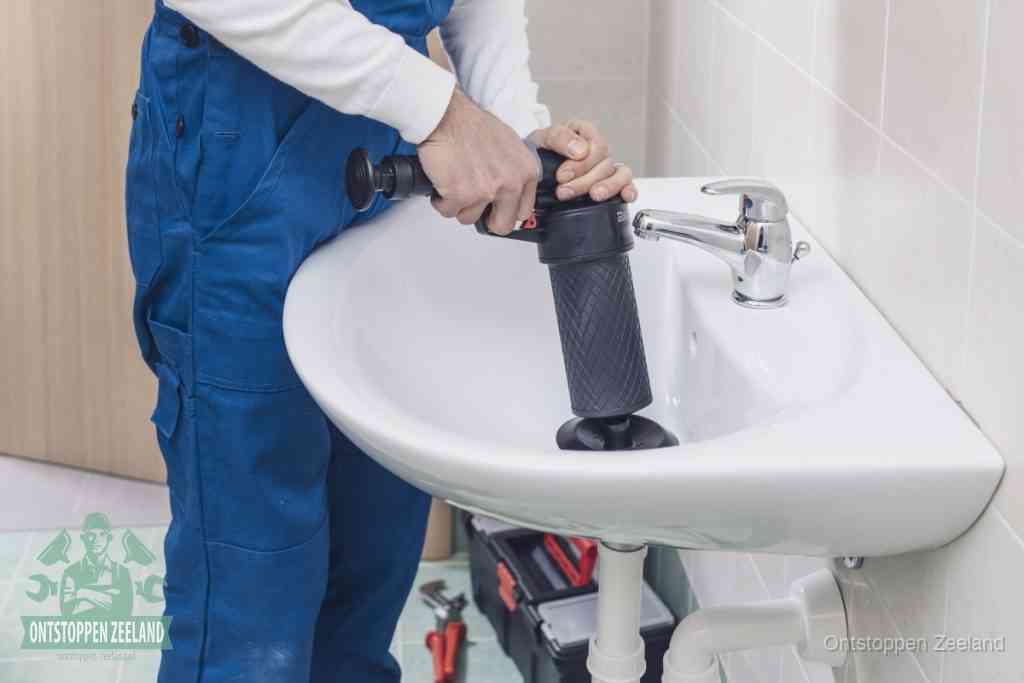 Een te ruwe doe-het-zelf poging met een hand-pomp op de afvoer van een badkamer-wastafel, een van de veelgemaakte fouten bij afvoer ontstoppen in Zeeland