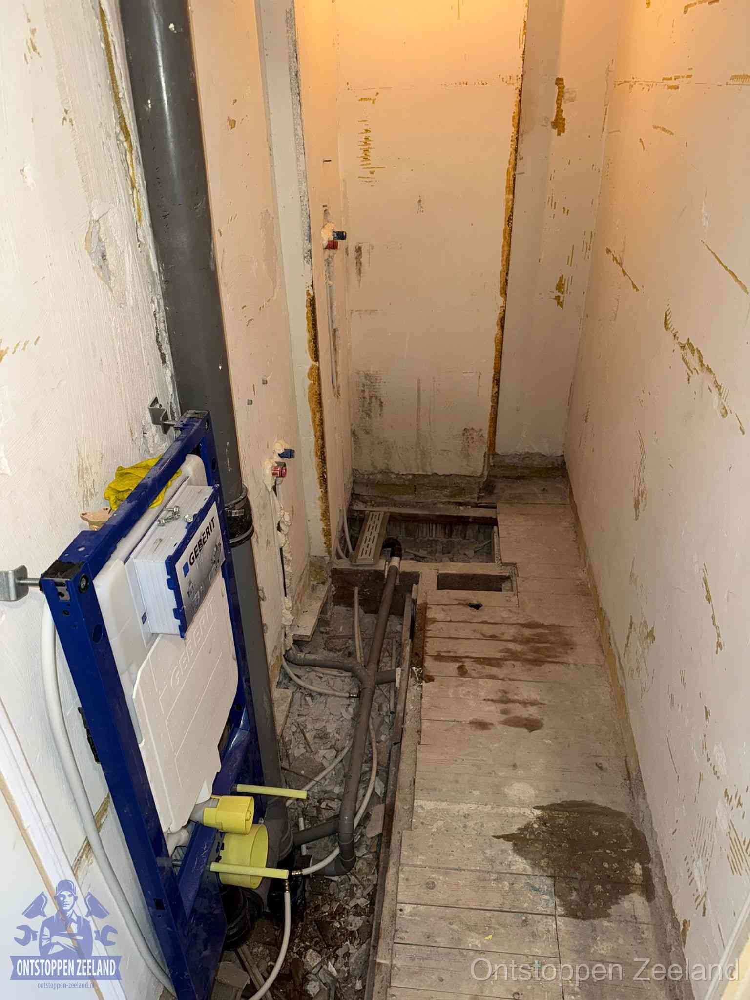 Een opgebroken toiletruimte tijdens renovatie met een Geberit inbouwreservoir en blootliggende oude afvoerleidingen, typisch voor oudere woningen in Zeeland